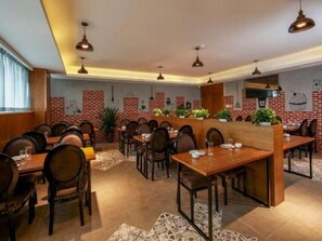 A restaurant with brick walls, wooden tables, and chairs. - James Joyce Coffetel (Chengdu)