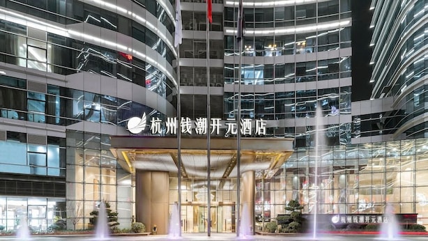 A modern hotel with a glass facade, multiple floors, and a central entrance with a fountain. - New Century Hotel Binjiang Hangzhou (Hangzhou)