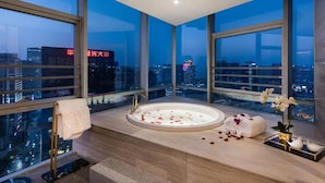 A modern bathroom with a large bathtub, city views, and a towel rack. - New Century Hotel Binjiang Hangzhou (Hangzhou)