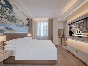 A hotel room with a large bed, a painting on the wall, a TV, and a desk with a lamp. - Nanshan Science Park, Vienna (Shenzhen)