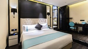 Une chambre d’hôtel avec un grand lit, un bureau, une chaise et un miroir.