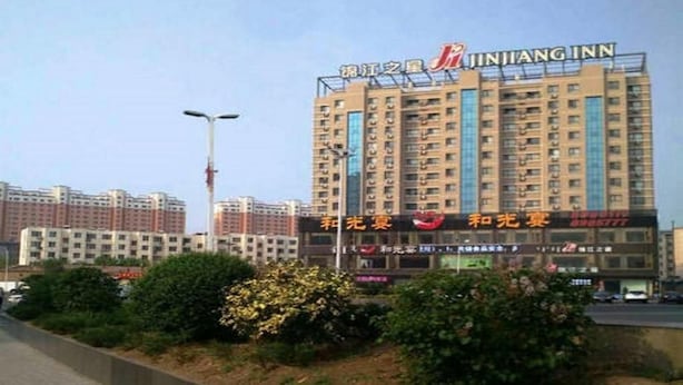 Ein mehrstöckiges Hotel mit Schildern, die es als Jintang Inn kennzeichnen.