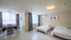 Ein Hotelzimmer mit zwei Betten, einem Schreibtisch und einem Stuhl.
