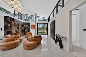 A modern interior with leather sofas, a large TV, and a bookshelf.