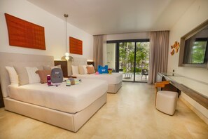 A hotel room with a large bed, a desk, and a view of palm trees through the window. - Family Selection At Grand Palladium Kantenah Resort & Spa (Kantenah)