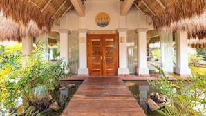 A wooden pathway leading to a double door with a circular sign above it. - Family Selection At Grand Palladium Kantenah Resort & Spa (Kantenah)