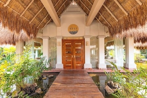 A wooden pathway leading to a double door with a circular sign above it. - Family Selection At Grand Palladium Kantenah Resort & Spa (Kantenah)