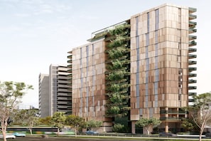 Un immeuble moderne de grande hauteur, doté de nombreux balcons et d’un jardin vertical.
