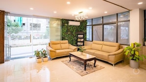 En moderne lobby med to sofaer, et sofabord og en bogreol.
