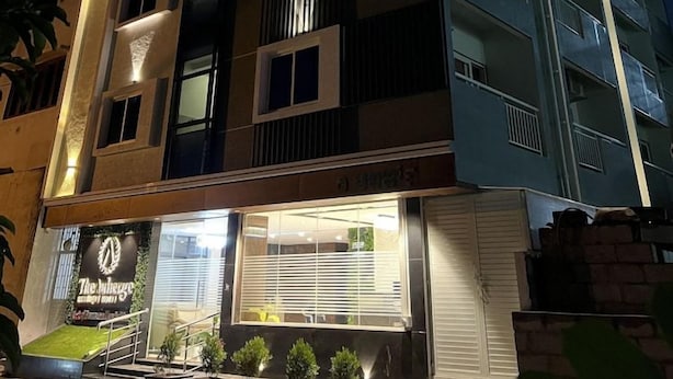 Et hotel med flere etager, altaner, en restaurant i stueplan og en velbelyst facade.
