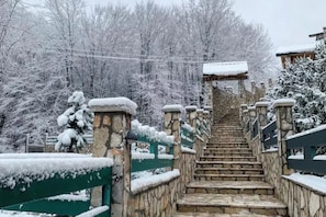 A stone staircase leading to a building with a snow-covered roof. - Garni Eco Hotel Elite Kolasin (Kolašin)