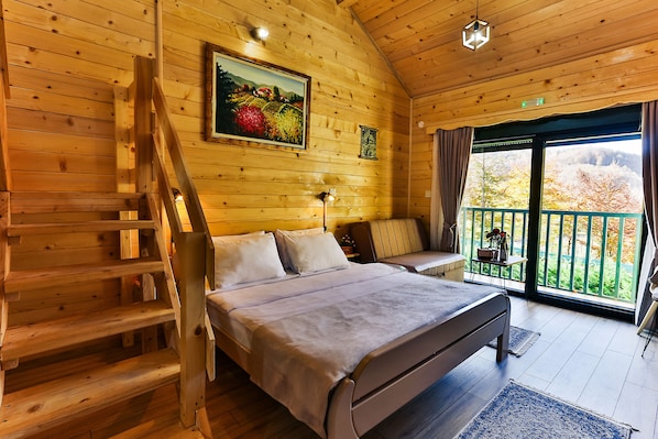 A wooden cabin bedroom with a bed, a bench, a ladder, a painting, and a balcony with a view. - Garni Eco Hotel Elite Kolasin (Kolašin)
