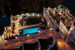 A stone patio with a swimming pool, outdoor seating, and a trampoline. - Garni Eco Hotel Elite Kolasin (Kolašin)
