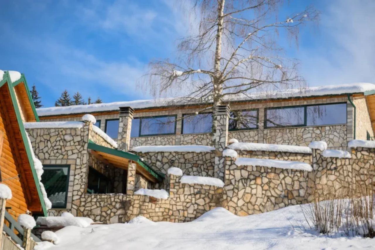 A stone building with a sloped roof and multiple windows.