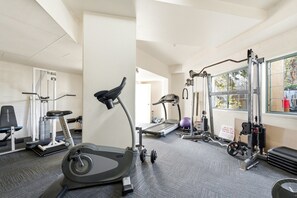 Ein Fitnessstudio mit Cardiogeräten, Kraftmaschinen und einem Fenster mit Blick.