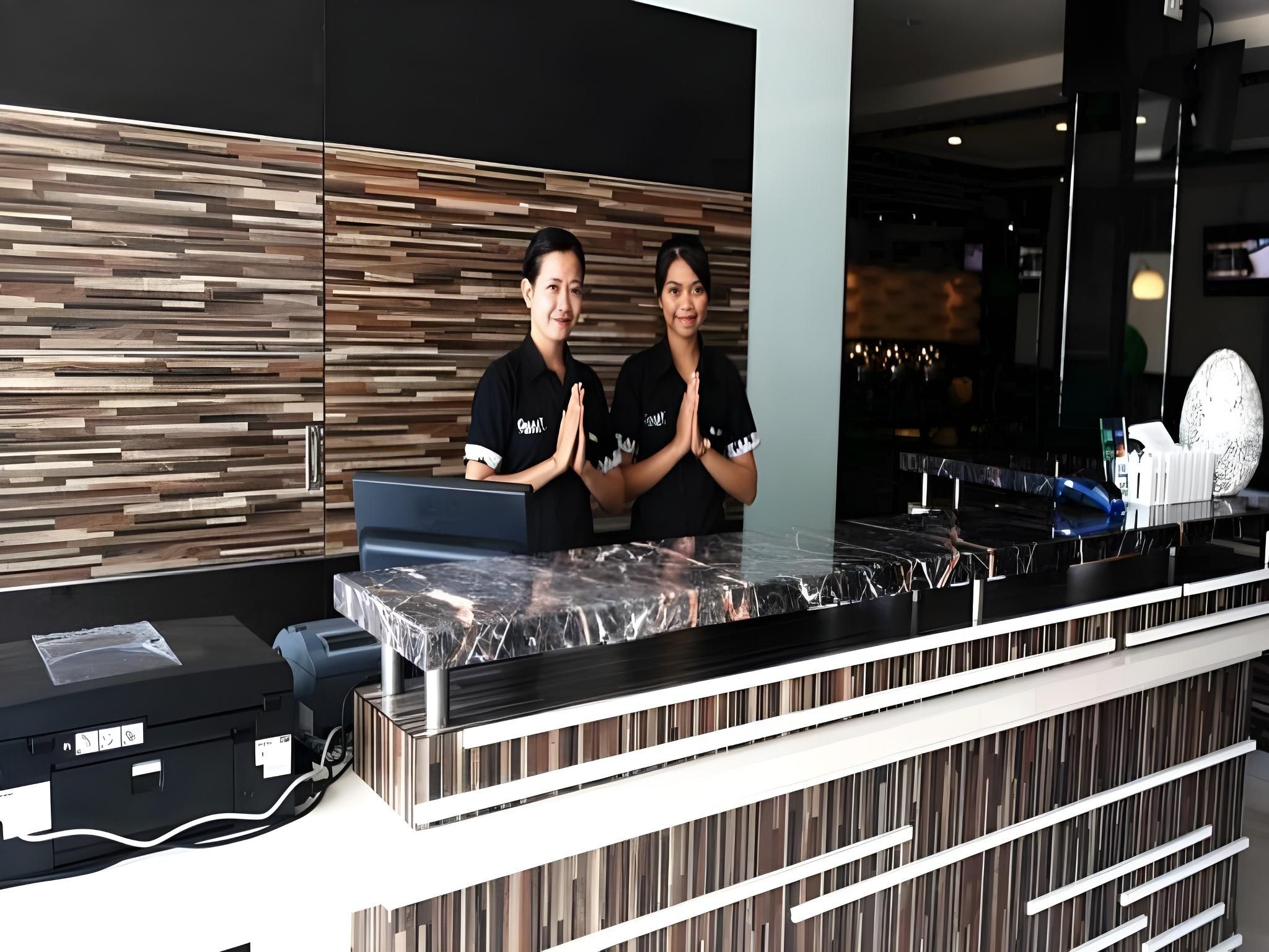 A reception desk with a modern design, a counter, and a wall with a wood-like pattern.