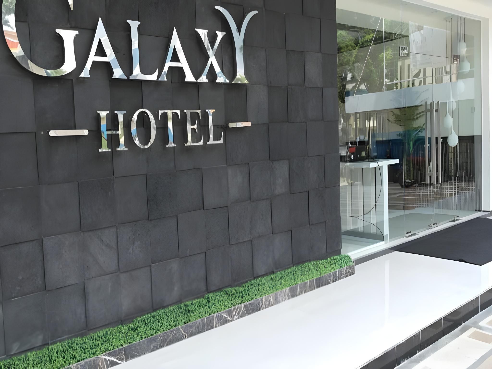 A hotel entrance with a dark facade and a sign that reads 'GALAXY HOTEL'.