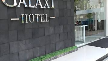 A hotel entrance with a dark facade and a sign that reads 'GALAXY HOTEL'.