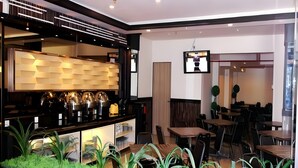 A modern interior with a bar area, seating, and a television screen. - Galaxy Hotel (Tarakan)