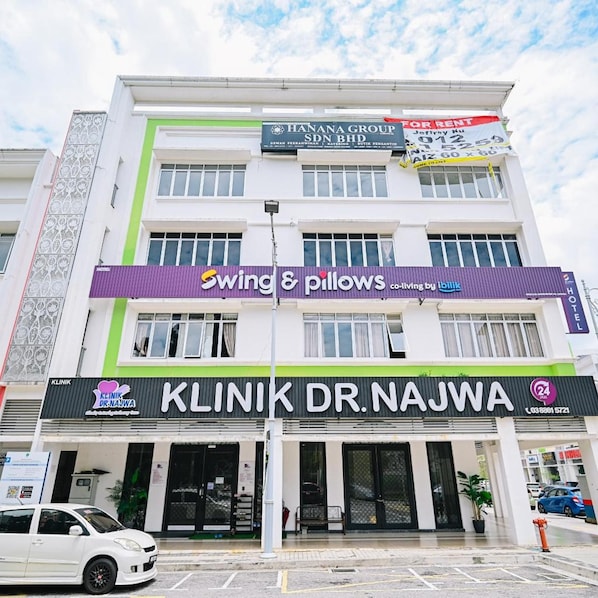 A multi-story building with commercial establishments including a hotel, a clinic, and a store named 'Swing & Pillows'. - Swing & Pillows @ Putrajaya (Putrajaya)