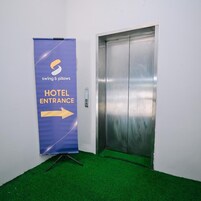 A hotel entrance with a blue banner indicating the direction to the hotel entrance and an elevator.