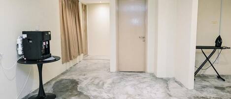 A hallway with a closed door, a table with a device, and a sign indicating a restroom.