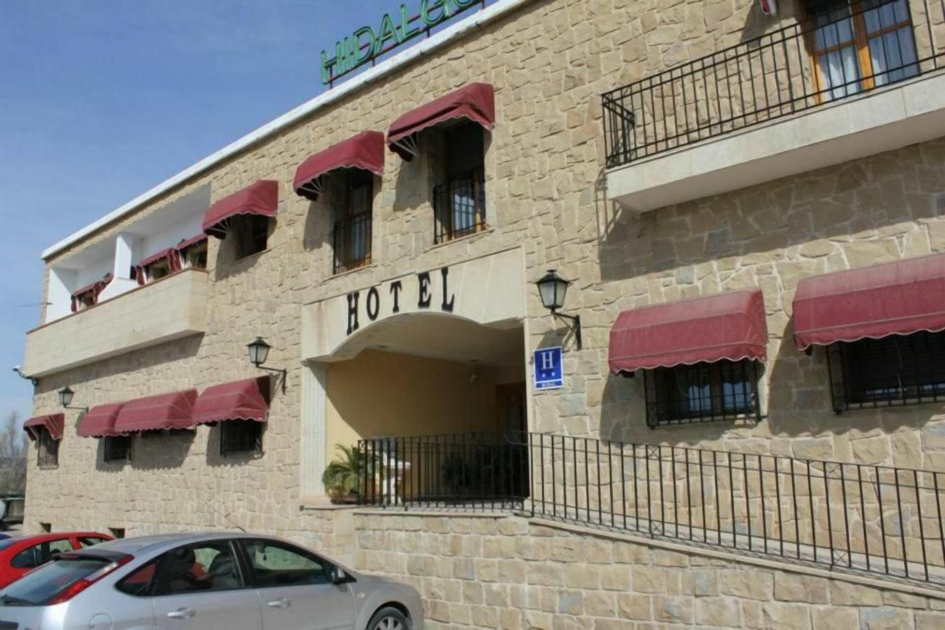 Un edificio de piedra con un letrero que dice 'HOTEL' y un letrero azul que indica una entrada accesible para personas con discapacidad.