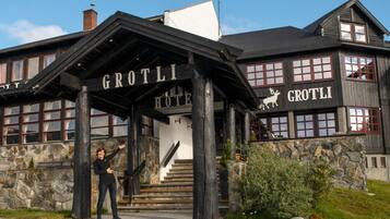 A wooden building with a sign reading 'GROTLI HOTEL' and a deer symbol.