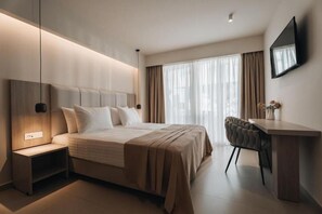 Una habitación de hotel moderna con una cama grande, una mesita de noche y un escritorio con una silla.
