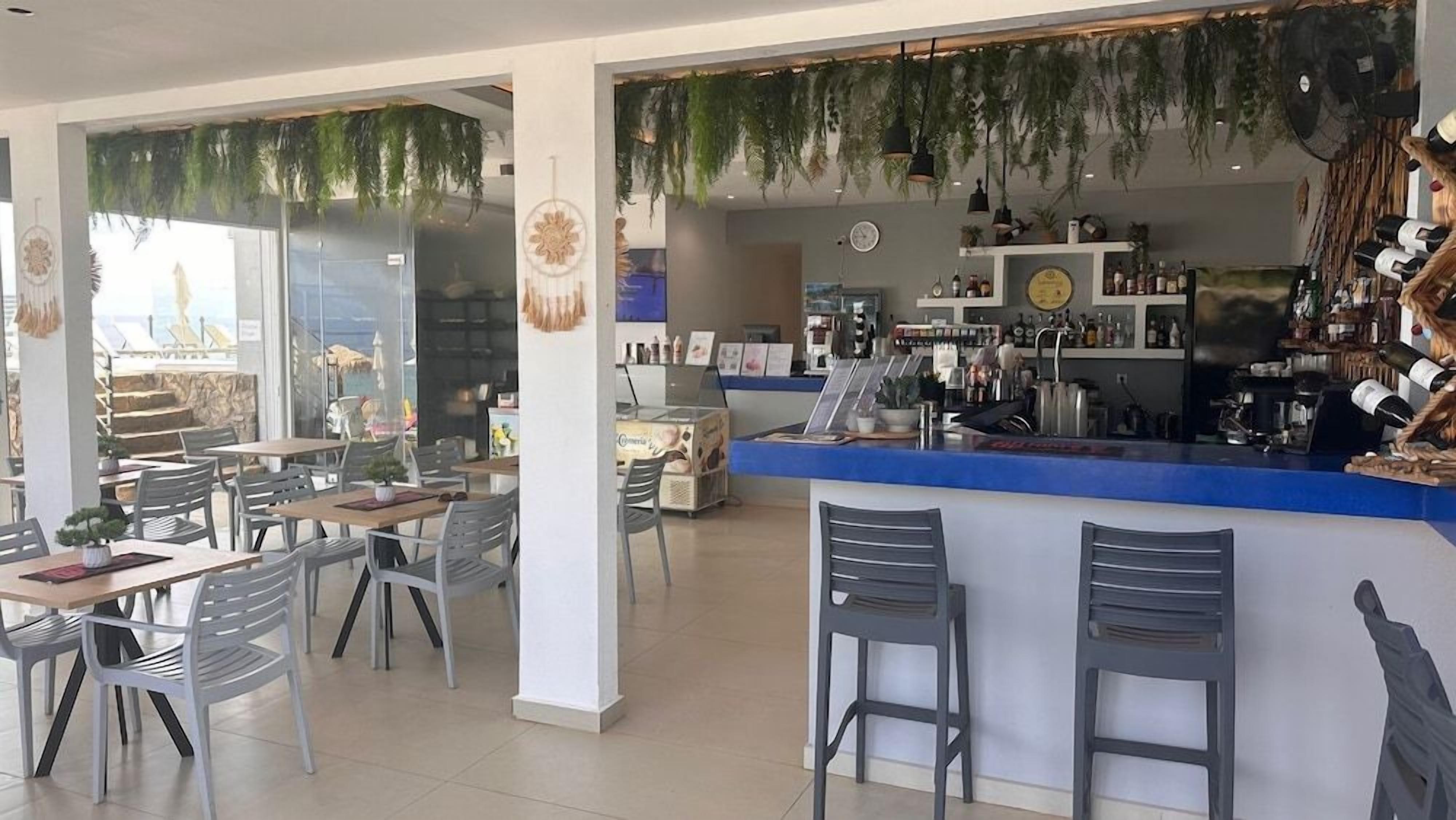 Een café met een bar, zitplaatsen en uitzicht door het raam.