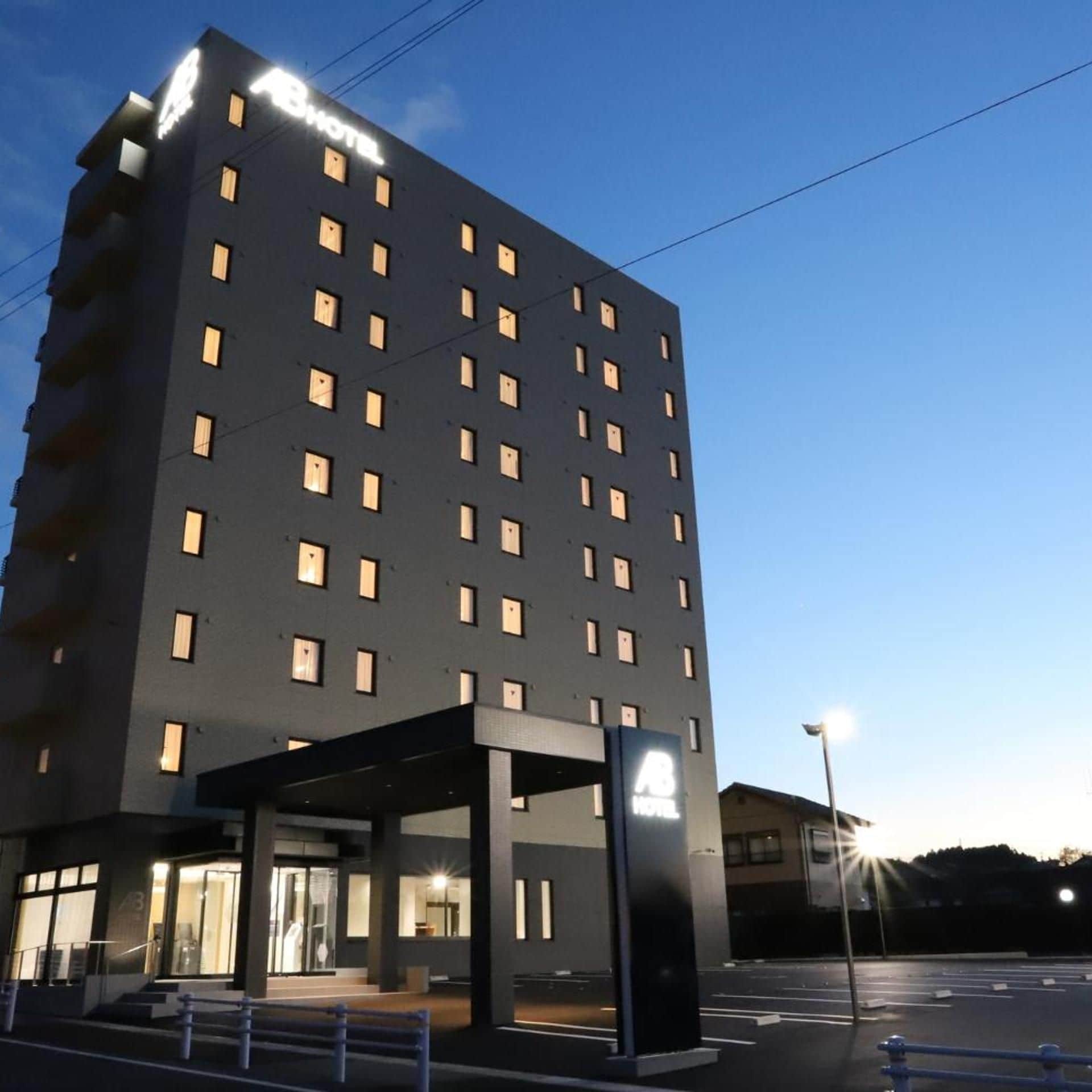 A multi-story hotel building with a modern design, featuring a prominent entrance with glass doors and a covered area.