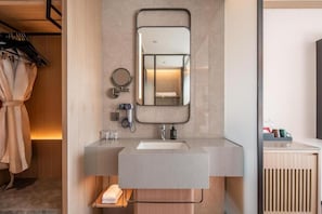 Een moderne badkamer met een grote spiegel, een wastafel en een handdoekrek.