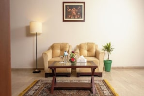 A room with a sofa set, a coffee table, a floor lamp, and a framed picture on the wall. - Faletti's Express - Shimla Hill (Lahore)