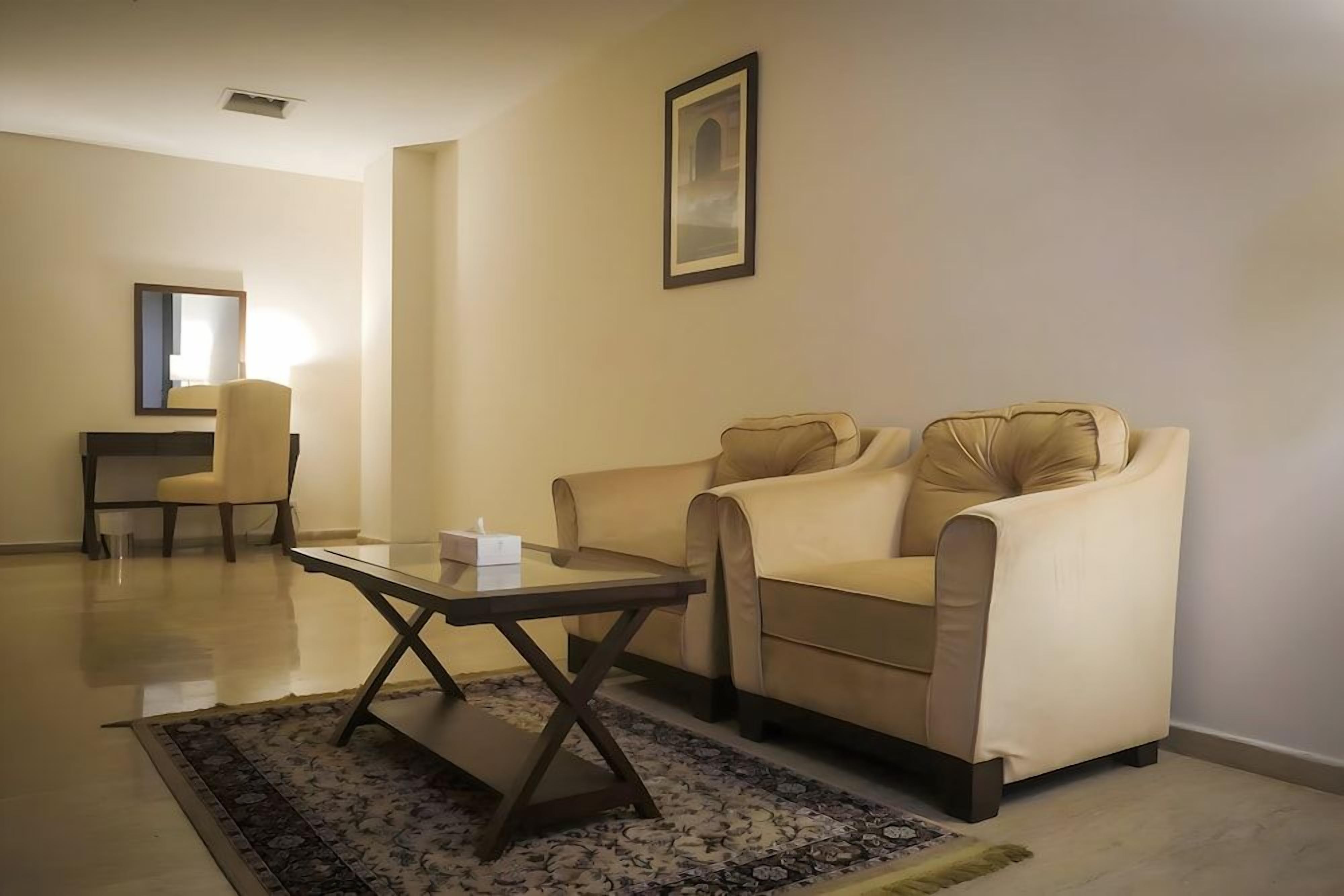 Un salon avec un canapé, une table basse et un fauteuil.