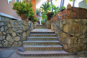 Un escalier avec des murs en pierre et des marches carrelées menant à l’entrée d’un bâtiment.