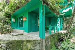 A green building with a covered outdoor seating area and steps leading to the entrance. - Belvilla Padma Legian Resort Near Monkey Forestnearubud Palace (Ubud)