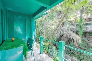 A balcony with a green railing, a table with a green tablecloth, and a chair. - Belvilla Padma Legian Resort Near Monkey Forestnearubud Palace (Ubud)
