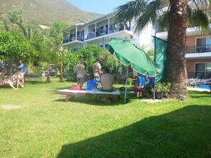 A hotel courtyard with outdoor seating, a pool, and a building with balconies. - Nefeli Wind Club (Lefkada)