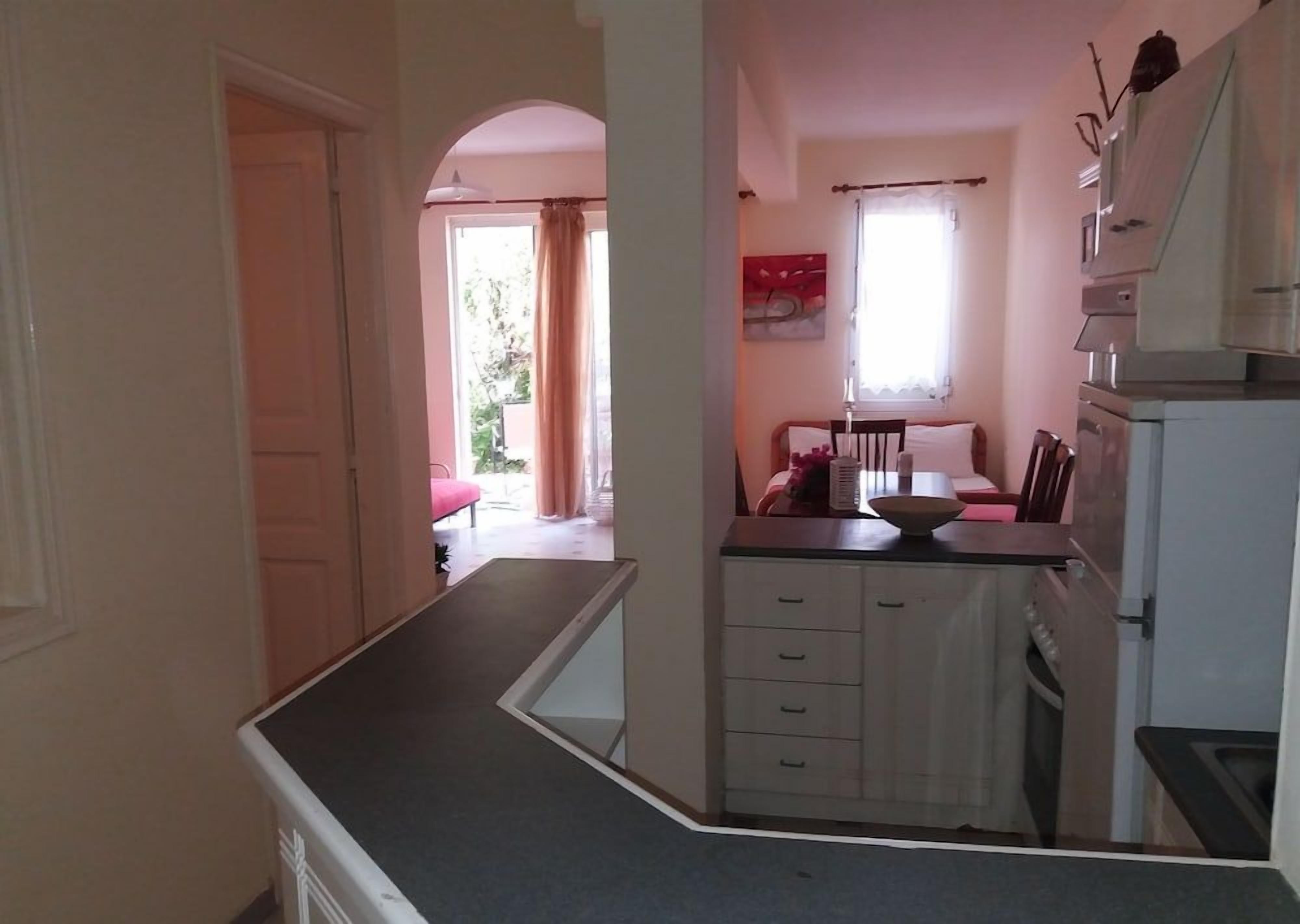 A kitchen with a countertop, cabinets, and a window.