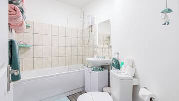 Un bagno con vasca, WC, lavandino e doccia.