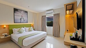 Habitación de hotel con cama, mesita de noche, lámpara, aire acondicionado, cortinas y vistas al exterior.