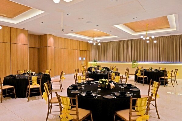 A conference room with round tables, chairs, and a modern ceiling design. - Click Hotel Biz Bangalore (Bengaluru)