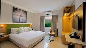 Una habitación de hotel con cama, mesita de noche, lámpara, equipo de aire acondicionado y televisor.