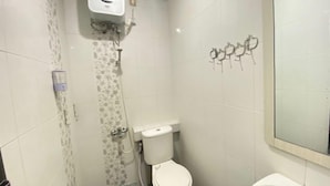 Een badkamer met een toilet, douche en wastafel.
