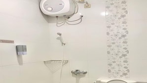 Een badkamer met toilet, douche en handdroger.