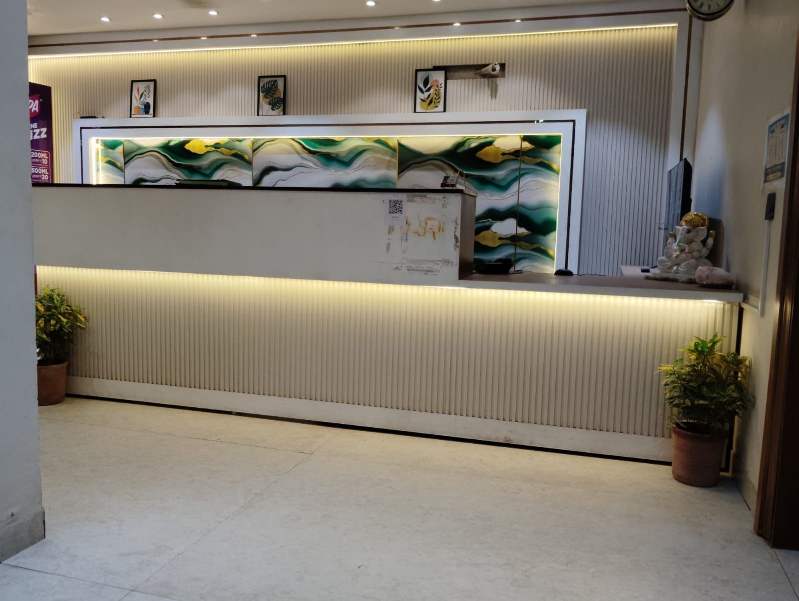 A reception desk with a modern design, featuring a textured wall and a decorative panel above it.