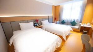 A hotel room with two beds, a desk, a chair, and a window with curtains. - Hongguo Hotel (Xiangyang)