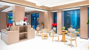 A modern hotel lobby with a reception desk, seating area, and large windows. - Hongguo Hotel (Xiangyang)