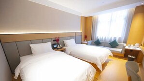 A hotel room with two beds, a desk, a chair, and a window with curtains. - Hongguo Hotel (Xiangyang)