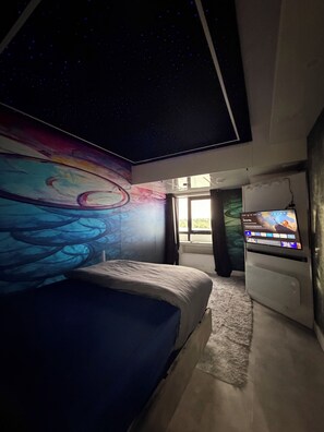A bedroom with a bed, a television, and a wall mural. -     Wow! River Views + Private Cinema (Limerick)
